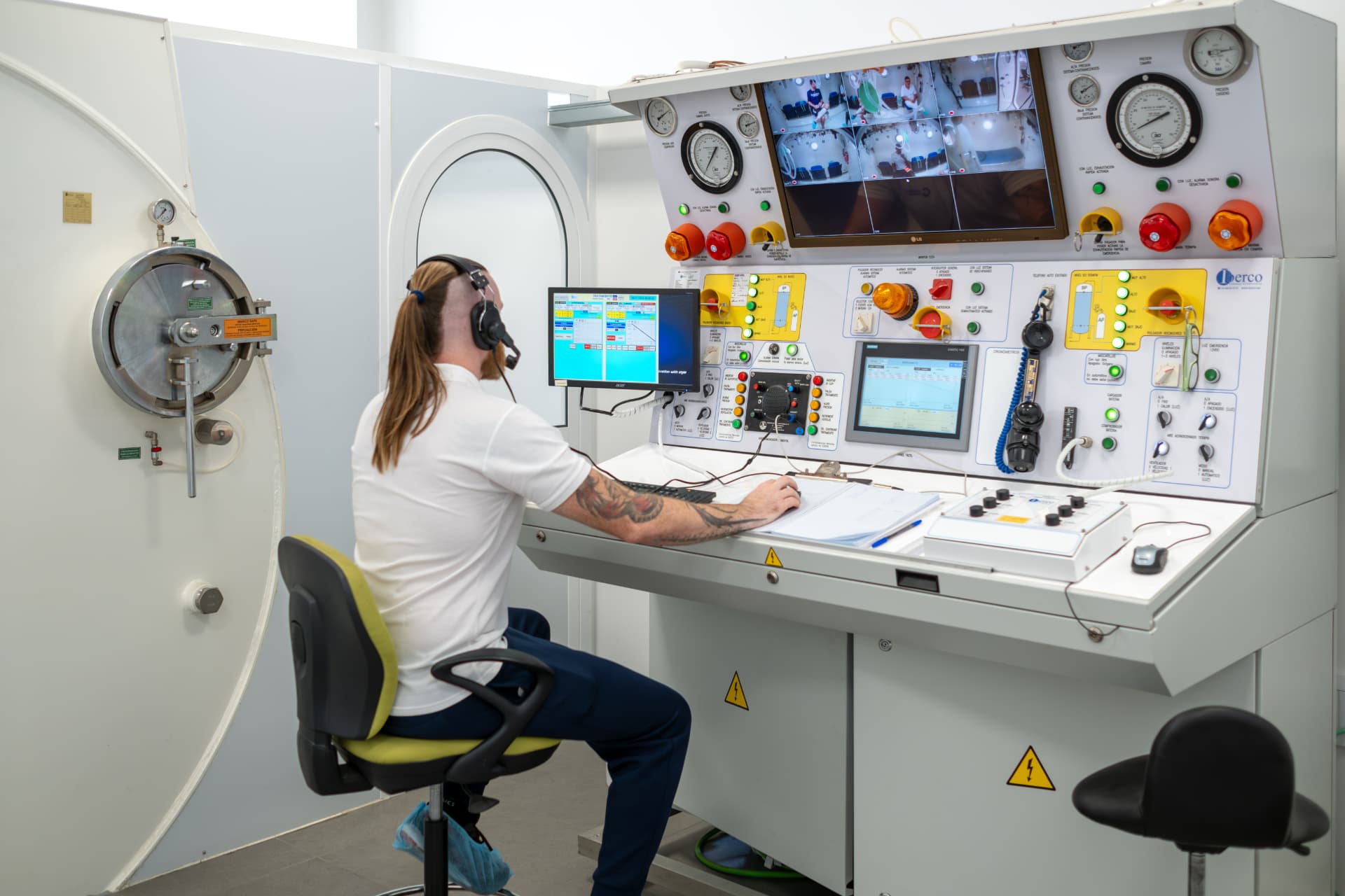 Técnico sanitario supervisando la sesión desde la consola de control de la cámara hiperbárica