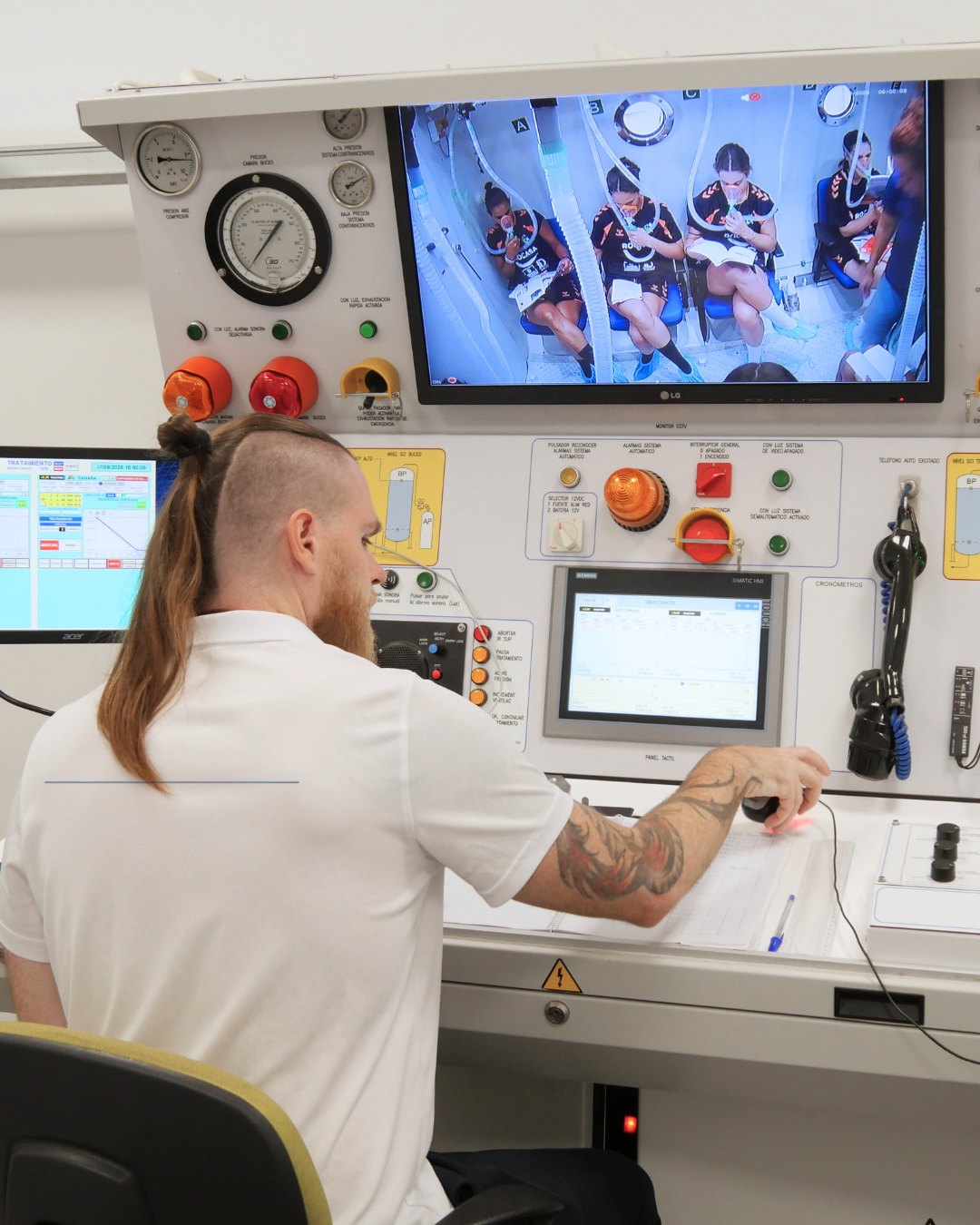 Técnico sanitario supervisando la sesión desde la consola de control de la cámara hiperbárica