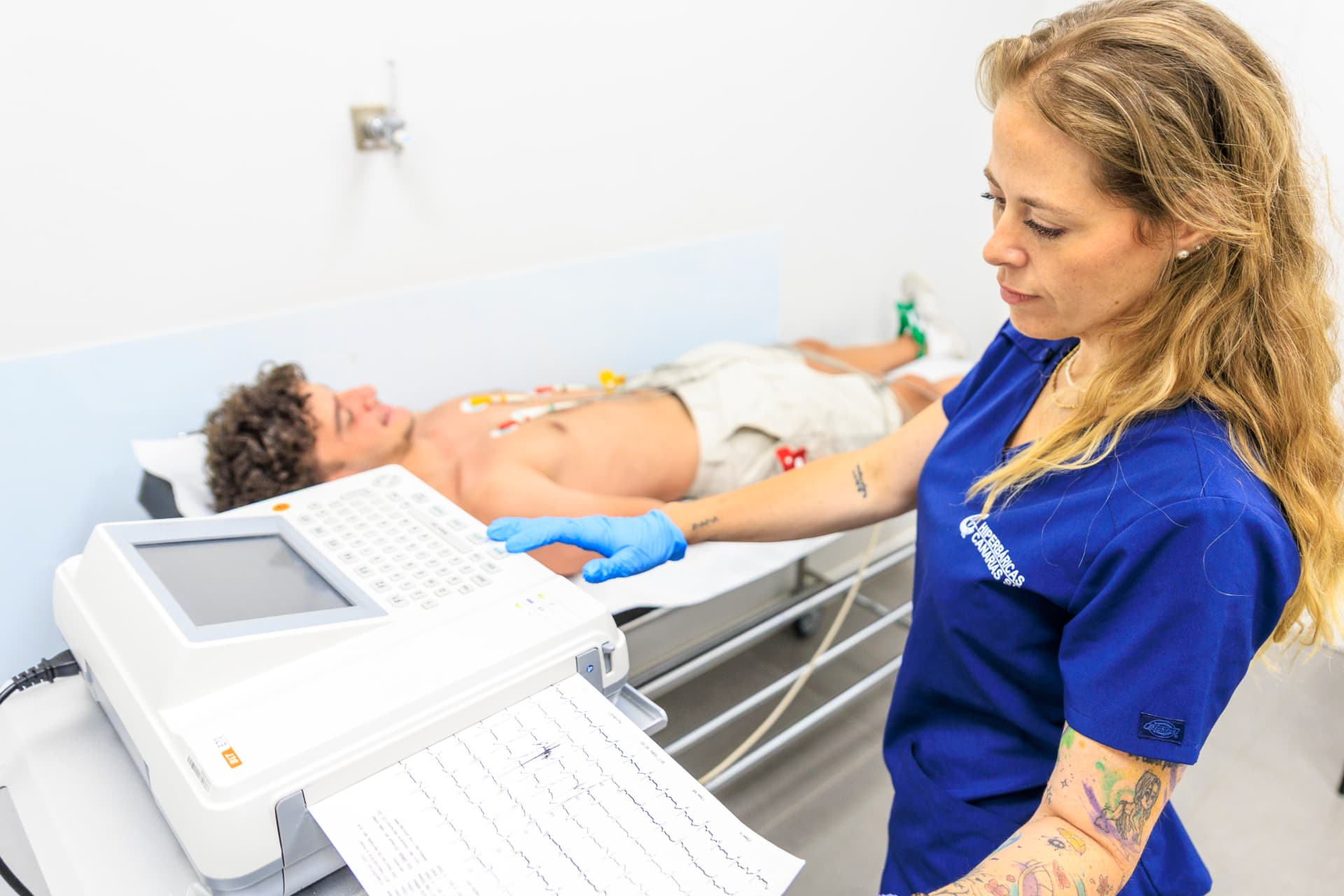 Profesional de Hiperbáricas Canarias realizando una prueba de esfuerzo con electrocardiograma a un paciente en consulta